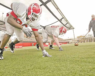 YSU senior Obinna Ekweremuba, left, works on staying low out of his stance during Monday’s practice at Stambaugh Stadium.