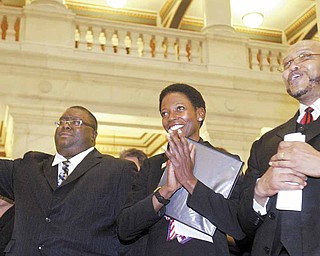 U.S. District Court Judge Benita Y. Pearson is flanked by the Rev. Dr. Lewis Macklin II, left, pastor of Holy Trinity Missionary Baptist Church in Youngstown, and the Rev. Kenneth Simon, pastor of New Bethel Baptist Church, also in Youngstown, as they sing “We Shall Overcome” during a memorial service for the Rev. Dr. Martin Luther King Jr. The Baptist Pastors’ Council of Youngstown and Vicinity sponsored the service Monday at the Mahoning County Courthouse rotunda.