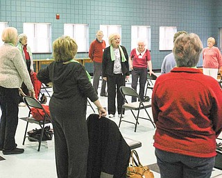 Eve Bevilacqua, local fitness instructor, talks to those attending a “Well of Body” class about how stretch bands can be used to exercise in a stationary position. The program was Tuesday at the Ursuline Center in Canfield.
