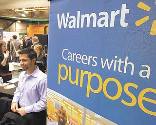 In this March 4, 2011 photo, representatives from Walmart speak to job seekers at the 32nd Annual Spring Career Fair at Cleveland State University. Over 120 organizations were on hand to talk to prospective candidates about employment and internships.
