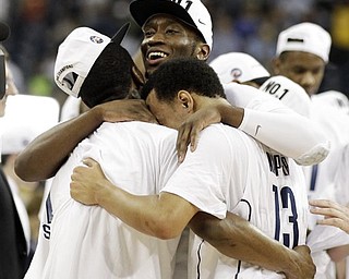 Connecticut's Alex Oriakhi center, and Shabazz Napier, right embrace a teammate after they won the men's NCAA Final Four college basketball championship game against Butler 53-41 Monday, April 4, 2011, in Houston.