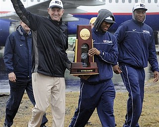 Connecticut head coach Jim Calhoun, left, walks with seniors Kemba Walker, center, and Donnell Beverly, right, as they arrive for a rally at Bradley International Airport in Windsor Locks, Conn., Tuesday, April 5, 2011. Connecticut beat Butler for the National championship in the NCAA Mens Final Four basketball tournament on Monday, April 4.