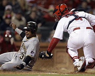 Pittsburgh Pirates' Jose Tabata, left, is tagged out at home by St. Louis Cardinals catcher Yadier Molina during the eighth inning of a baseball game Monday, April 4, 2011, in St. Louis.