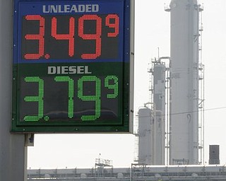 In this March 30, 2011 file photo, a Houston gas station displays its prices with a refinery stack in the background. Quick: What do these things have in common? Libyan leader Moammar Gadhafi. The Japanese earthquake and tsunami. Wall Street volatility. A cranky, even angry American populace. Answer: They all have something to do with gasoline. No matter what happens in the world today, just about everything seems to point back to fuel and the tricky politics that emerge when prices spike.