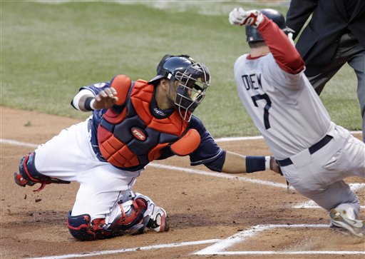 Cleveland Indians catcher Carlos Santana, left, tags out Boston Red Sox's J.D. Drew in the second inning in a baseball game Tuesday, April 5, 2011, in Cleveland. Drew tried to score on a single by Jarrod Saltalamacchia. 