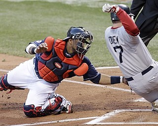 Cleveland Indians catcher Carlos Santana, left, tags out Boston Red Sox's J.D. Drew in the second inning in a baseball game Tuesday, April 5, 2011, in Cleveland. Drew tried to score on a single by Jarrod Saltalamacchia.