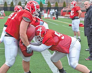 Youngstown State off ensive lineman Zach Larson (56) practices hits Wednesday at YSU’s Stambaugh Stadium. Larson, who has the reputation for his off -the-fi eld antics, has received more attention this spring for his on-fi eld exploits.