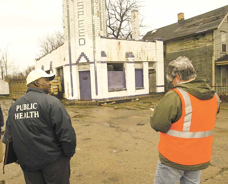 Cicero Davis, environmental health director for the Youngstown Health Department, and Brenda Williams, the city’s chief building official, take note of an abandoned gasoline station at 1225 Oak Hill Ave. during a Friday inspection. 