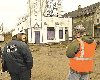 Cicero Davis, environmental health director for the Youngstown Health Department, and Brenda Williams, the city’s chief building official, take note of an abandoned gasoline station at 1225 Oak Hill Ave. during a Friday inspection.
