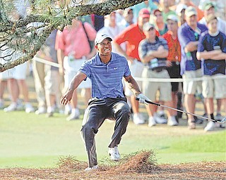 Tiger Woods nearly falls backwards after hitting out of the rough on the 17th hole during the third round of the Masters golf tournament Saturday, April 9, 2011, in Augusta, Ga.