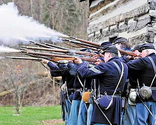 Members of the Western Pennsylvania Civil War Reenactors Society fire their rifles during a spring drill Saturday afternoon at the Raisch Log Cabin in Sharpsville Community Park in Sharpsville, Pa.