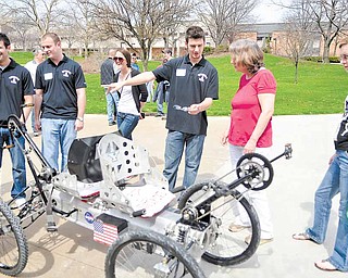 Youngstown State University senior mechanical-engineering student Kevin Miller speaks to Susan Halley of Pittsburgh about the moon buggy he and fellow students built. The lunar vehicle was one of many projects the YSU College of Science, Technology, Engineering and Mathematics displayed as attractions at Sunday’s annual STEM showcase at Moser Hall.