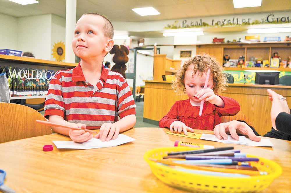 Brody Cheney, 5, and his sister, Noelle, 3, create “All About Me” books at a craft table in the children’s room at Hubbard Public Library, 436 W. Liberty St., Hubbard. The library hosted an open house Sunday afternoon, and about 200 people attended.  