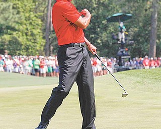 Tiger Woods reacts after an eagle putt on the eighth hole during the final round of the Masters golf tournament Sunday, April 10, 2011, in Augusta, Ga.