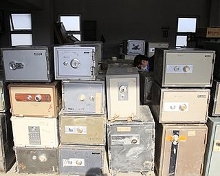 In this photo taken on April 7, 2011, a police office cleans cashboxes after they collected those from damaged houses at a police station in tsunami-hit Ofunato city, Iwate Prefecture, Japan. Safes were washing up along the tsunami-battered coast, and police were trying to find their owners, a unique problem in the country where many people, especially the elderly, still stash their cash at home.