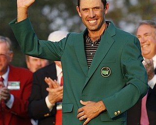 Charl Schwartzel of South Africa waves with his green jacket after winning the Masters championship golf tournament Sunday, April 10, 2011, in Augusta, Ga.