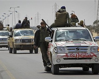 Rebel fighters retreat out of Ajdabiya during an advance by pro-Gadhafi forces, on the outskirts of Ajdabiya, Libya Saturday, April 9, 2011. Government soldiers and rebel gunmen battled in the streets of the key front-line city of Ajdabiya Saturday after the Libyan military used shelling and guerrilla-style tactics to open its most serious push into opposition territory since international airstrikes began.