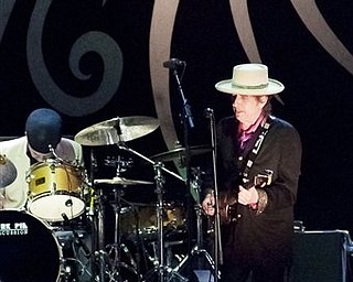 In this handout photo released by Saigon Sound System, US musician Bob Dylan , right, performs with his band in Ho Chi Minh City, Vietnam Sunday, April 10, 2011. After nearly five decades of singing about a war that continues to haunt a generation of Americans, legendary performer Bob Dylan finally got his chance to see Vietnam at peace. Dylan, 69, jammed on stage in a black jacket, purple shirt and white hat in the warm evening air, singing favorites such as "A Hard Rain's a-Gonna Fall" and "Highway 61 Revisited."