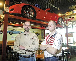 Dave Millich, left, president of the Mahoning Valley Corvettes club, stands near his 2010 Corvette Grand Sport on display at Quaker Steak & Lube in Austintown. His 1984 Fitch High School classmate Rob Bowman, right, has a 1967 Chevy Chevelle on display at the restaurant.