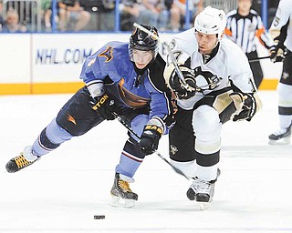 Atlanta Thrashers center Alex Burmistrov, left, of Russia, and Pittsburgh Penguins left wing Mike Rupp vie for the puck during the first period of an NHL hockey game, Sunday, April 10, 2011, in Atlanta.