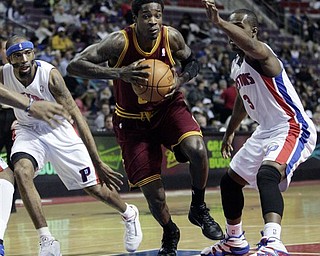 Cleveland Cavaliers' Manny Harris, center, drives to the basket between Detroit Pistons' Richard Hamilton, left, and Rodney Stuckey (3) in the first half of an NBA basketball game Monday, April 11, 2011, in Auburn Hills, Mich.