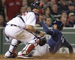 Tampa Bay Rays' B.J. Upton, right, scores on a double by John Jaso as Boston Red Sox catcher Jarrod Saltalamacchia waits for the ball during the fifth inning of a baseball game in Boston, Monday, April 11, 2011.