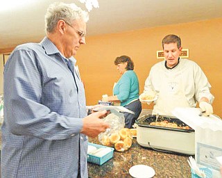 Winter warm up: Rosetta Hall at St. Rose Church, 58 E. Main St., Girard, was the setting recently for an annual Winter Warm-Up Cook-Off. Casseroles, soups and appetizers were prepared by 16 area chefs and were sampled and judged by those attending the fundraiser. Prizes were awarded for foods judged best in each category. Monsignor John A. Zuraw, one of the competing chefs, served a dish of kielbasa and sauerkraut sliders to Anthony Ciccone, at left, during the event.