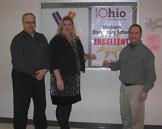 Growing green: Struthers Elementary School Principal Maggie Kowach accepts a check for $250 from Tom Baringer, left, treasurer of Struthers Rotary, and Bryan Higgins, Rotary president. The funds will support the principal’s “Green Zone Team,” which presents rewards to students who had good behavior and stayed in the green zone on the behavior chart for a whole month. Pictures of those special students are placed in a display case in the commons area of the school.