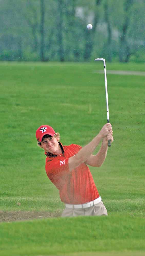 Youngstown State senior golfer and nursing major Spenser Sulzener hits his ball out of a sand trap. 

