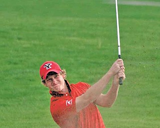 Youngstown State senior golfer and nursing major Spenser Sulzener hits his ball out of a sand trap.