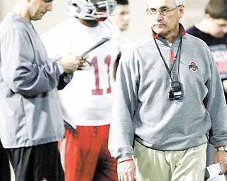 Ohio State head coach Jim Tressel, right, walks away as assistant head coach Luke Fickell, left, looks over a list of plays during the first day of spring NCAA college football practice Thursday, March 31, 2011, in Columbus, Ohio.
