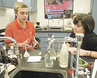 Students Vince DeChellis and Becca Mowad work together in their 11th grade chemistry class at Poland Seminary High School. The two are earning credit toward their college degrees in a program called College in High School.