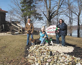 Standing outside The Lake House, from left, are Lora Herbert with Dancer, Sally Geary with Marble and Darby, and HSCC Shelter Manager Heather Jurina with Mel.