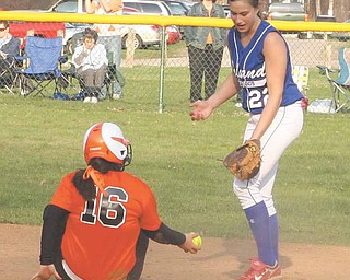 Howland baserunner Tori McCormick (16) flips the ball to Poland’s second baseman Erin Gabriel (22) during their All-American Conference Red Tier showdown Thursday afternoon at Lewis Field in Howland Township Park. Tied until the fifth inning, the Bulldogs began a rally when Gabriel hit the first of her two home runs to put Poland ahead 4-3.The Bulldogs, who added five more runs inthe sixth on another homer by Gabriel and an RBI single by Adriana Sikora, would go on to defeat the Tigers, 10-4.