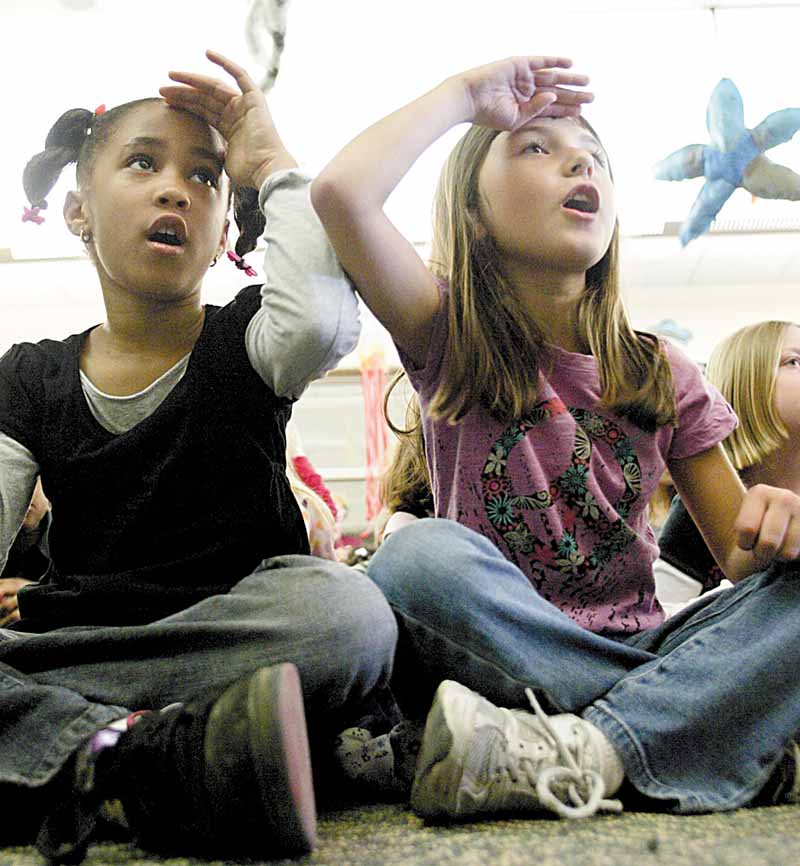 Taylor Black, left, and Marisa Batrone follow instructions from storyteller Jocelyn Dabney, who used music, poetry and body movements to involve students in the stories. She said the “call and response” is part of storytelling.