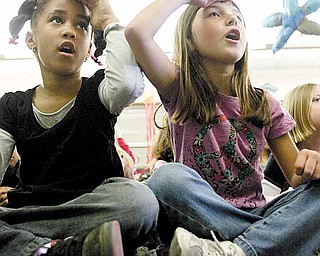 Taylor Black, left, and Marisa Batrone follow instructions from storyteller Jocelyn Dabney, who used music, poetry and body movements to involve students in the stories. She said the “call and response” is part of storytelling.