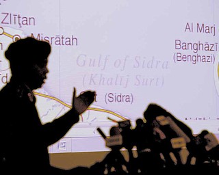 Libyan Army Maj. Gen. Saleh Abdullah Ibrahim gestures during a press conference in Tripoli, Libya, Saturday, April 16, 2011. In the background is a map of Libyan Eastern coastal areas  involved in the fighting. 