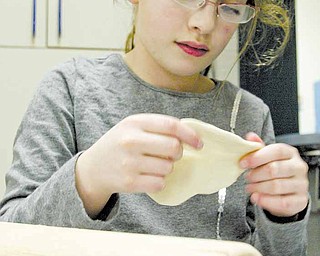 Anna Kan, a second-grader at Akiva Academy in Youngstown, prepares matzah dough. Susan Schonberger, Judaica coordinator, said the key is not to let the dough leaven or raise. Matzah, unleavened bread, is a reminder of how the ancient Israelites left Eygpt in haste and had no time to let their bread raise. Passover, which begins at sundown tonight, celebrates freedom.  
