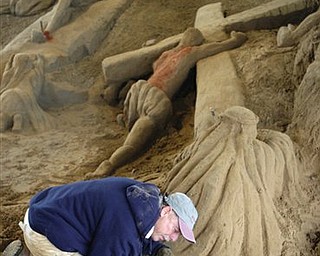 Artist Roger Powell brushes sand while constructing his 12th annual Easter sand sculpture "Walking on Common Ground" at the Hancock County Fairgrounds in Findlay, Ohio, Tuesday, April 19, 2011. The sculpture uses about 300 tons of sand and is expected to be completed on Good Friday.