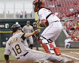 Pittsburgh Pirates' Neil Walker (18) scores as Cincinnati Reds catcher Ryan Hanigan waits for the throw in the first inning of a major league baseball game, Monday, April 18, 2011 in Cincinnati. Walker scored on a hit by Chris Snyder. 