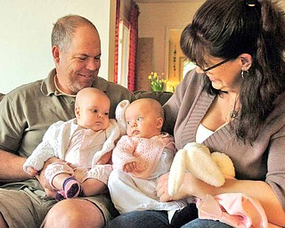Mike Rose, left, holds daughter Sophia as Stephanie Lovell-Rose, right, holds Sophia's twin sister Allison at home in El Cerrito, California, March 24, 2011. Allison and Sophia, who were born premature, receive supplemental milk from the Mother's Milk Bank.