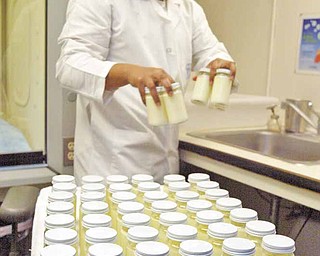 Gerald Astrero, a lab technician at the Mother's Milk Bank, prepares donated breast milk for distribution in San Jose, California, March 22, 2011. The 37-year- old non-profit distributes 420,000 ounces of breast milk a year.