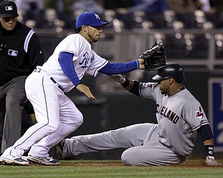 Cleveland Indians' Carlos Santana, right, beats the tag by Kansas City Royals third baseman Mike Aviles, left, to advances to third on a single by Travis Hafner during the ninth inning of a baseball game Wednesday, April 20, 2011, in Kansas City, Mo.