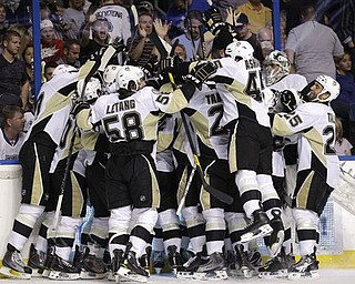 Pittsburgh Penguins players mob James Neal after he scored the game-winning goal during double-overtime in Game 4 of a first-round NHL Stanley Cup playoff series on Wednesday, April 20, 2011 in Tampa, Fla.