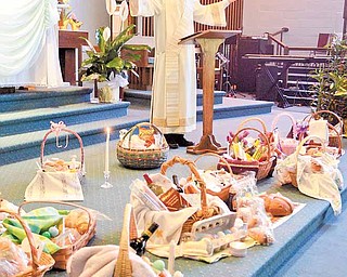 Deacon Nick Moliterno blesses parishioners’ Easter baskets, which he says represent the heavenly feast that awaits Christians.