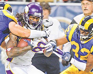 Donovan Fletcher’s brother, Bradley (32), moves in for a tackle on Vikings receiver Sidney Rice in a 2009 game.