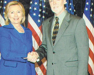 Secretary of State Hillary Clinton greets Ron Elkins, a Poland native who retired and returned to the Mahoning Valley after 23 years as a foreign service officer. Clinton was Elkins’ 
former boss.