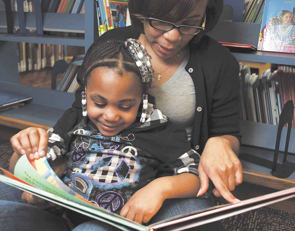 Nikida Davis, a Lakota English teacher,  reads with her daughter, Nia, 5, at the Westwood Public Library. Nikida is one of 15,397 parents who have applied for an Ohio Ed Choice voucher for a chance at a private school for Nia.  