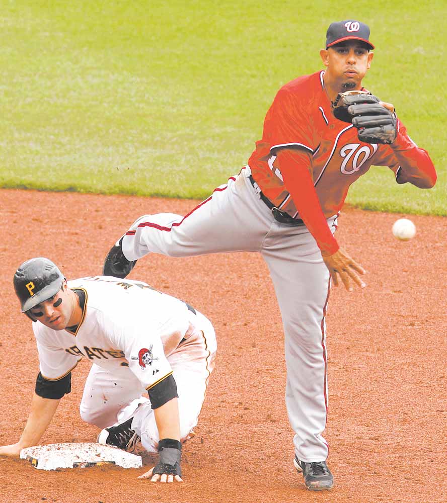 Washington Nationals shortstop Alex Cora, right, throws to first after getting the force at second on Pittsburgh Pirates' Neil Walker in the fifth inning of a baseball game in Pittsburgh, Sunday, April 24, 2011. Pirates' Garrett Jones was safe at first on the fielder's choice. The Nationals won 6-3. 