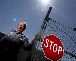 In this April 21, 2011 photo, 95-year-old Ernest "Boonie" Ankrum stands at a gate at the Holophane facility in Newark, Ohio. Ankrum is retiring from his job as a gate guard. 